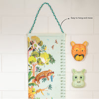 Children's growth chart with jungle design and animal-themed wall decor on a tiled wall