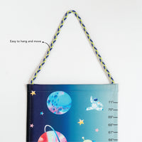 Children's growth chart with space-themed design and hanging cord .