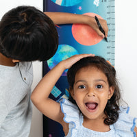 Child measuring height with a colorful growth chart Zookeeper
