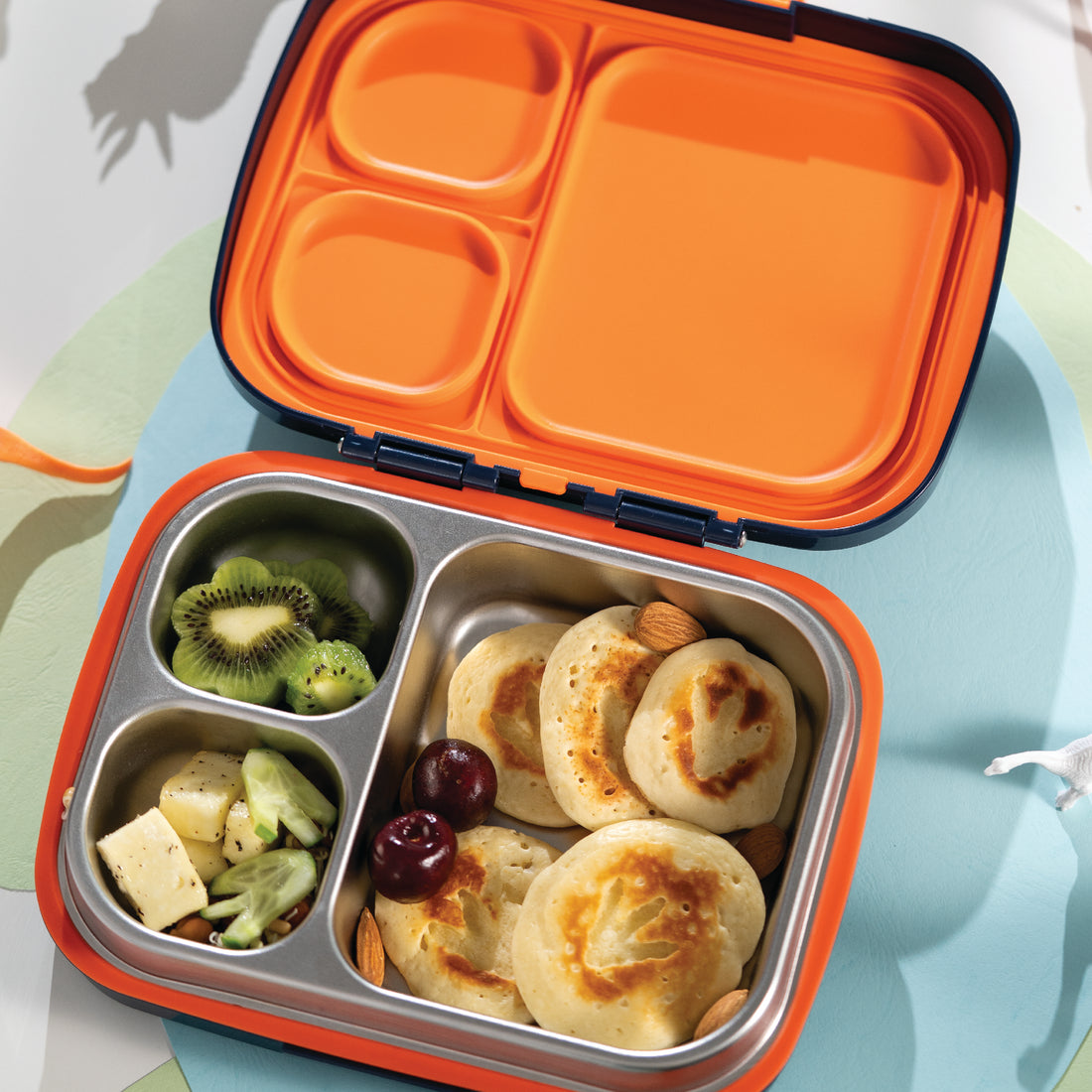 Kids Bento Lunch Box with stainless steel compartments filled with snacks and fruit showing portioned meal prep for school lunch use
