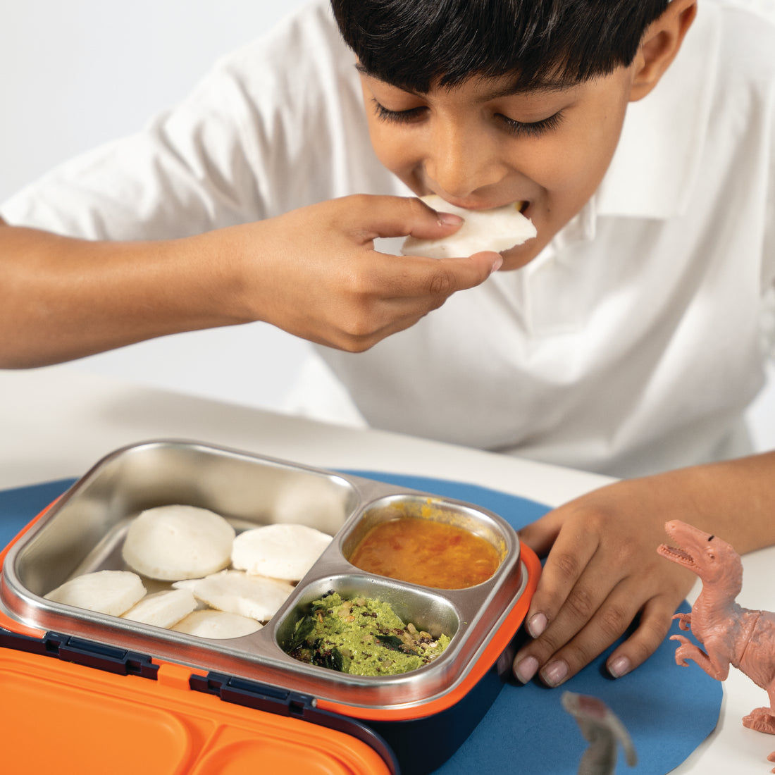 Kids Bento Lunch Box with child eating meal from stainless steel compartments showing school lunch use and portioned food storage